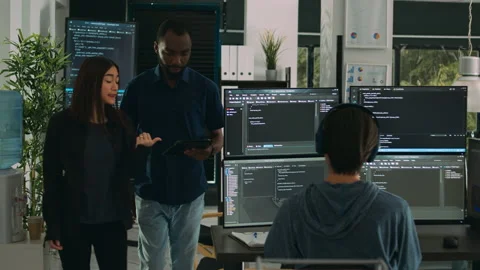 Software programmers talking about algorithms on big screen and tablet 動画素材 221744512