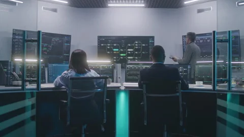 Software programmers work on computers in monitoring control room Stock Footage 244410329