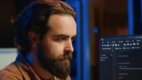 Software technician in apartment office deeply immersed in coding, close up 스톡 사진