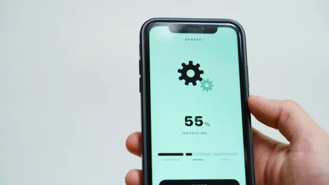 Software update downloading at percent on smartphone screen with rotating gears Stock Footage 343238311