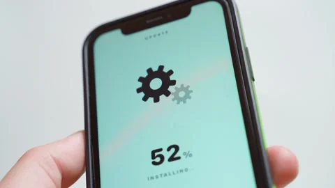 Software update downloading on smartphone screen with gear icons close-up. Vídeos de archivo 342735553