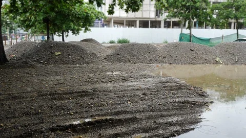 Soil pile material in construction industry, slow motion rainy day scene Stock Footage 98225889