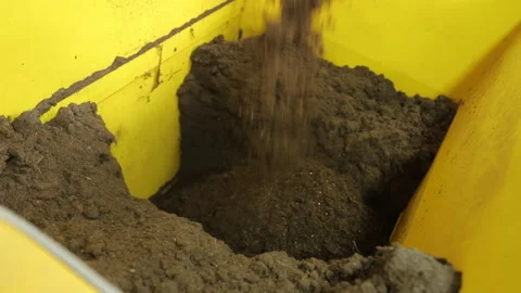 Soil preparation, fertilizers. A large container is filled with the substance Stock Footage 176847701