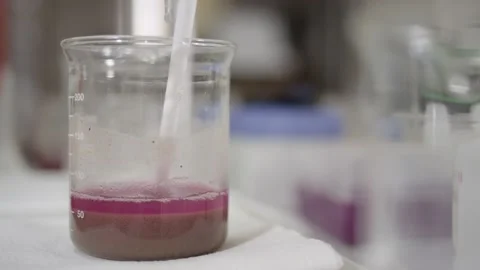 Soil settling out of a solution in glass beaker in chemical laboratory Stock Footage 144137019