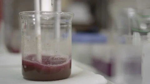 Soil in solution being mixed and tested in glass beaker in chemical laboratory Stock Footage 144137305