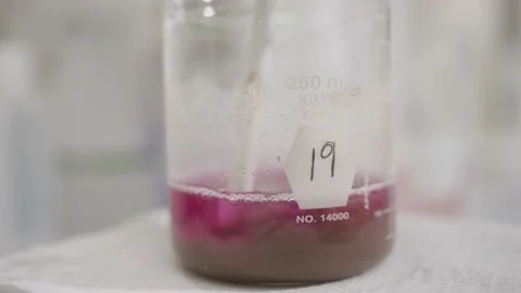 Soil in solution being mixed and tested in glass beaker in chemical laboratory Stock Footage 144137576