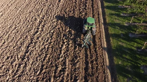 Soil tillage with tractor at sunset Video stock 163211720
