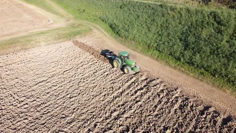 Soil tillage with tractor at sunset Stock-Footage 163219376