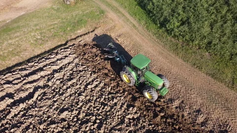 Soil tillage with tractor at sunset Stock Footage 163219414