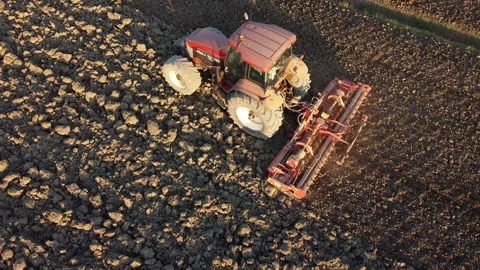 Soil tillage with tractor at sunset Stock Footage 163233985