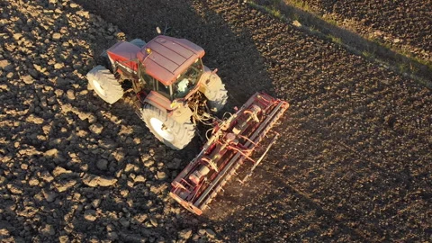 Soil tillage with tractor at sunset Vídeo Stock 163234495