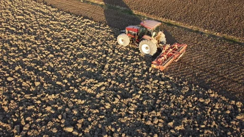 Soil tillage with tractor at sunset Stock-Footage 163234643