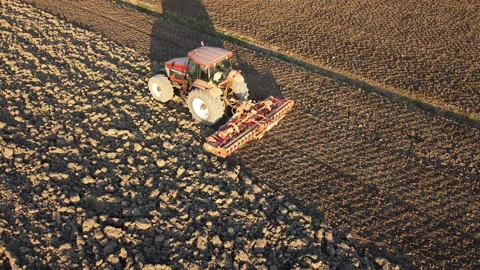 Soil tillage with tractor at sunset Видео 163234948