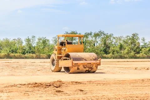 Soil vibration roller during sand compacting works at construction site Stock Photos