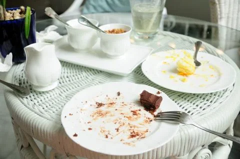 Soiled cake plates on rattan table Stock Photos