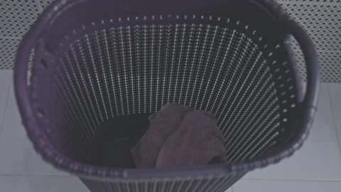 Soiled towels fall into spacious laundry basket in bathroom Stock Footage 250287654