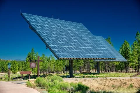 Solar array of panels on a beautiful countryside under a blue summer sky. Stock Photos
