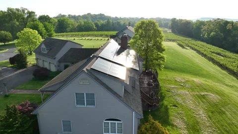 Solar array reflects sunlight. Aerial view of large American home in rural Stock Footage 241241865