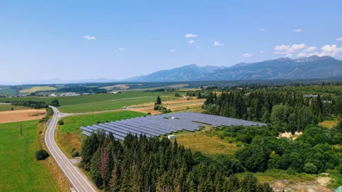 A solar array stands beside a road through Slovak farmland. Gray panels fill a Stock Footage 347013674