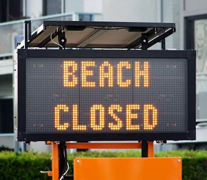 A solar board trailer with the statement "Beach closed" 库存照片