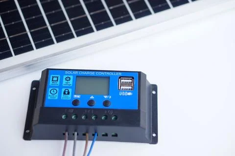 Solar charge controller with USB port connected to wiring, placed near solar pan Foto stock