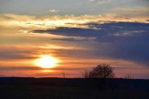 The solar disk sets in the clouds. Evening in the foothills of the Western Ur Stock Photos