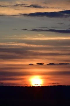 The solar disk sets in the clouds. Evening in the foothills of the Western Ur Stock Photos