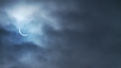 Solar Eclipse in a cloudy blue sky left side of the screen Stock Footage 112507127