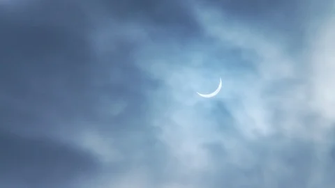 Solar Eclipse in a cloudy light blue sky 3 Stock Footage 112518914