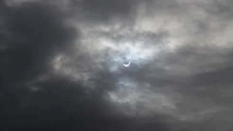 A solar eclipse in cloudy weather through a cloud. partial solar eclipse. Stock Footage 219997429
