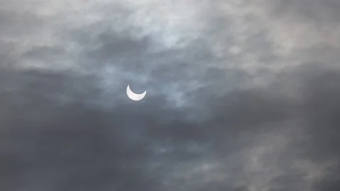 A solar eclipse in cloudy weather through a cloud. partial solar eclipse. Stock Footage 220434513