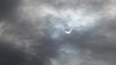 A solar eclipse in cloudy weather through a cloud. partial solar eclipse. Stock Footage 221100119