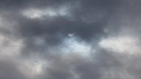 A solar eclipse in cloudy weather through a cloud. partial solar eclipse. Stock Footage 221790076