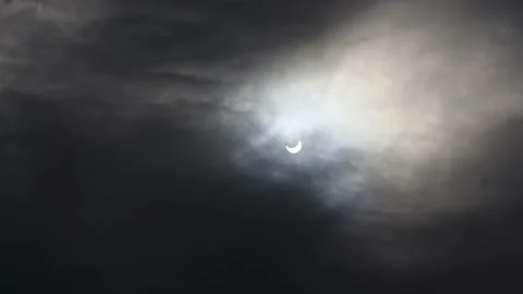 A solar eclipse in cloudy weather through a cloud. partial solar eclipse. Stock Footage 222433089