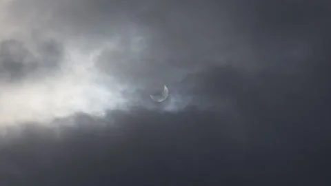A solar eclipse in cloudy weather through a cloud. partial solar eclipse. Stock Footage 223405621