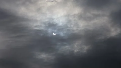 A solar eclipse in cloudy weather through a cloud. partial solar eclipse. Stock Footage 226432838