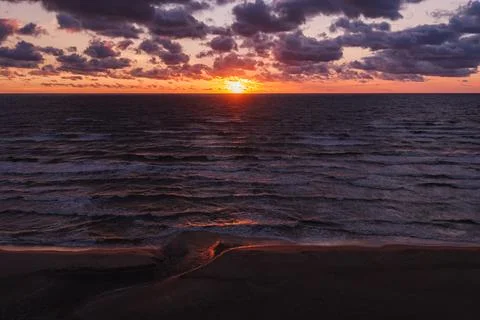Solar eclipse during sunset over ocean and sandy beach Stock Photos