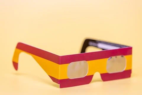 Solar eclipse glasses with Spain flag design filtering sun Stock Photos
