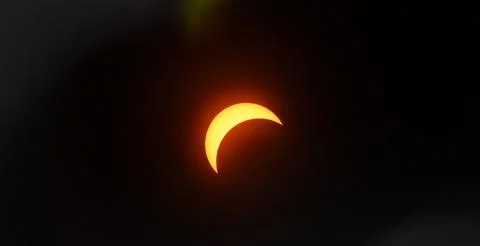 Solar eclipse with a glowing crescent in the dark sky Stock Photos