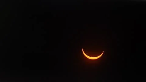 Solar eclipse with a glowing crescent in the dark sky Stock Photos