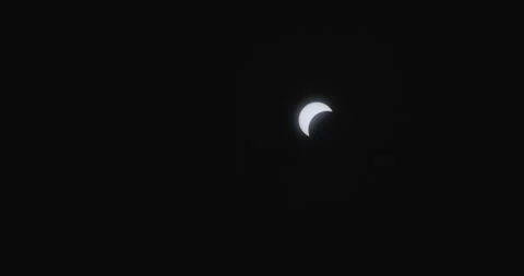 A solar eclipse with the moon partially covering the sun in a dark sky Stock Footage 276837750