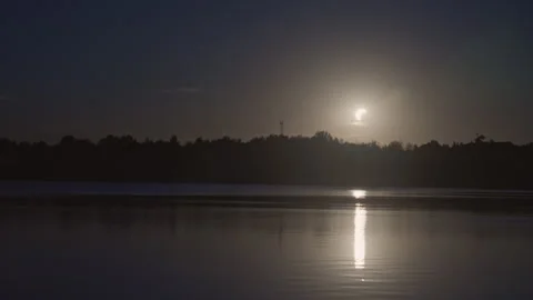 Solar eclipse over lake in timelapse at dusk Stock Footage 343318861