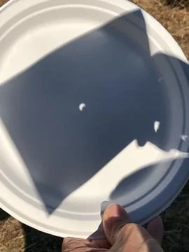 Solar Eclipse. The sun shadow reflected on a plastic dish Fotos de archivo