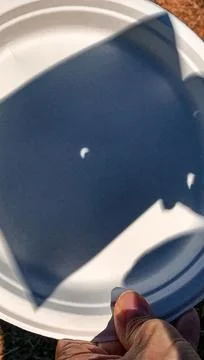 Solar Eclipse. The sun shadow reflected on a plastic dish Fotos de archivo