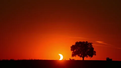 Solar eclipse sunset time lapse with silhouettes on the horizon Stock Footage 343377216