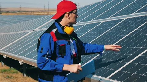Solar energy engineer checking solar panels at a solar power facility Stock Footage 144245121