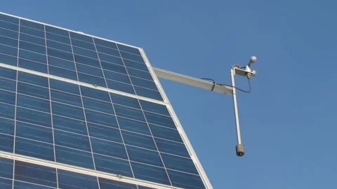 Solar energy panels with wind meter against blue sky Video stock 171664341