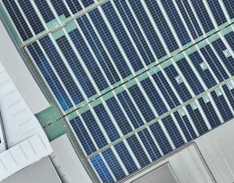 Solar energy system installed on the rooftop of an industrial factory and w.. 库存照片