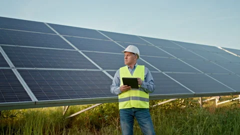 Solar engineer checking photovoltaic panels. Solar farm. Stock Footage 197983599