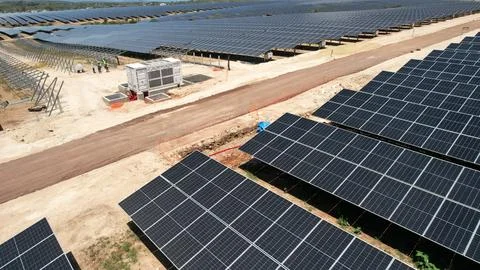 Solar farm with an access road cutting through panel rows Fotos Stock